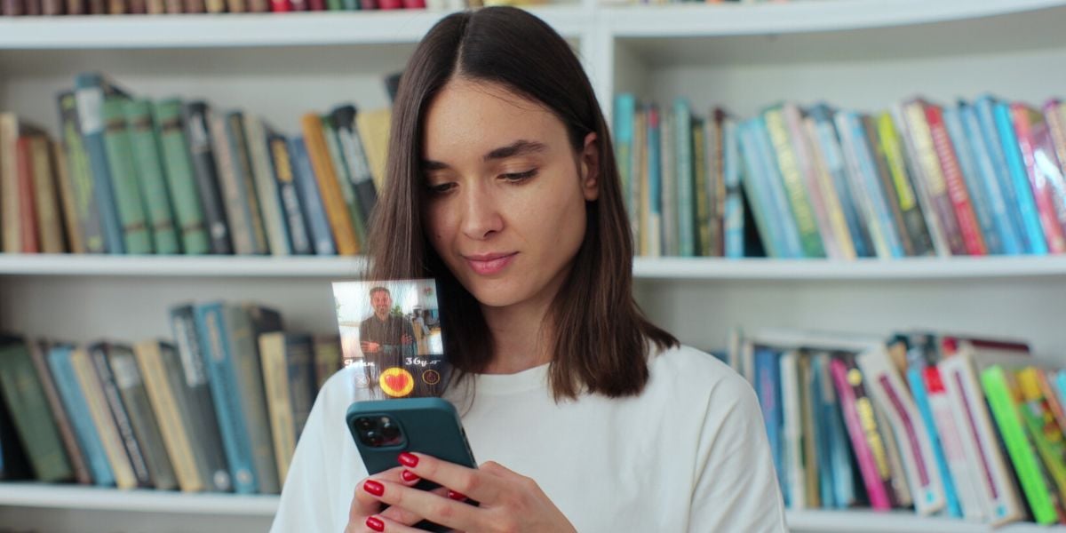 woman looking at phone with social media icons